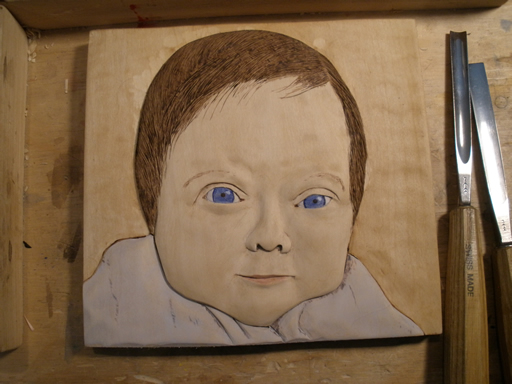 relief woodcarving of baby